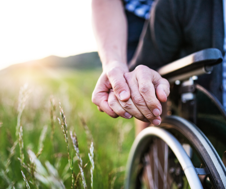 hand on hand of person in wheelchair